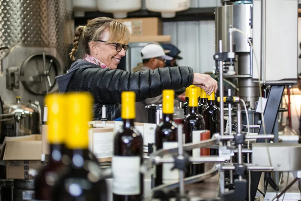Worker checking bottles on a beverage bottling line