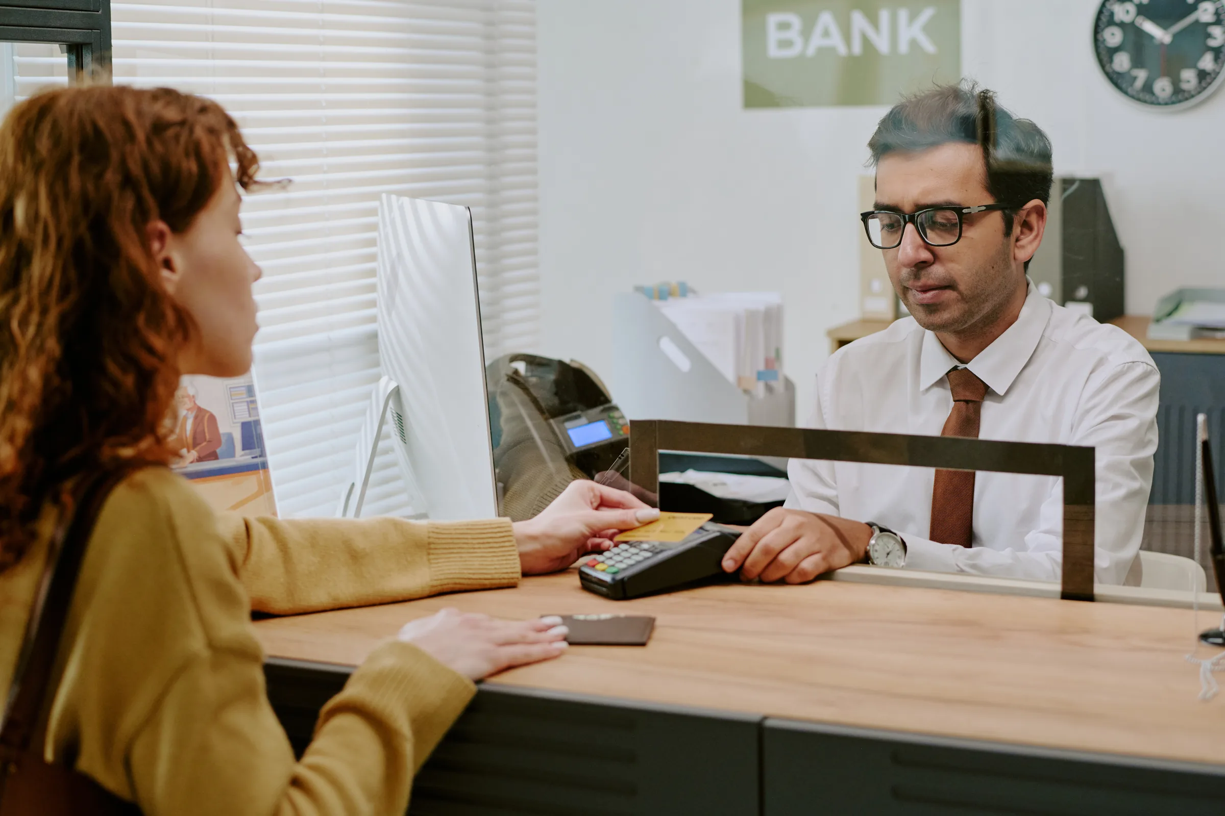 Bank teller serving a customer at the counter