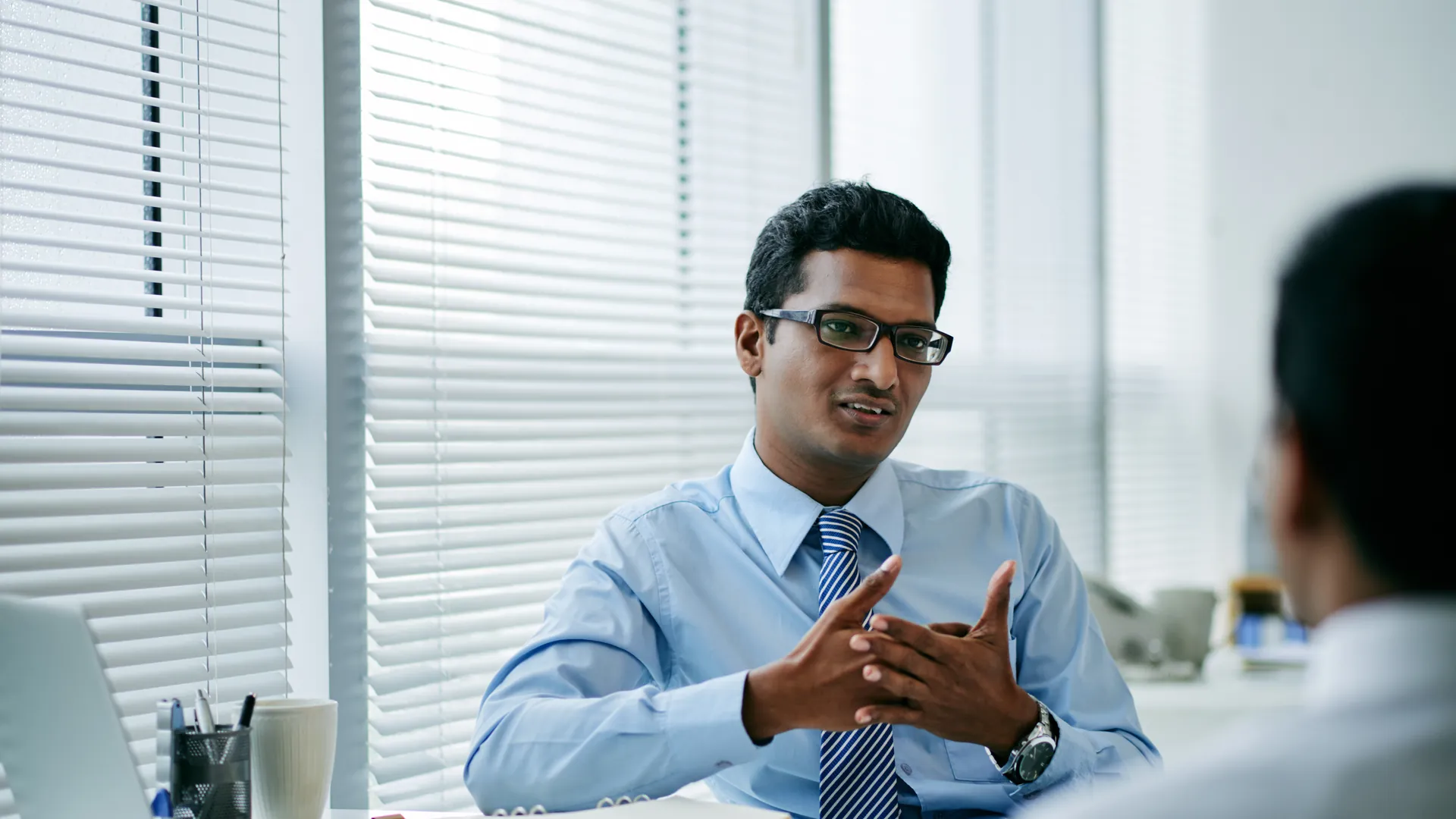 HR manager in a one-on-one conversation with an employee in a bright modern office