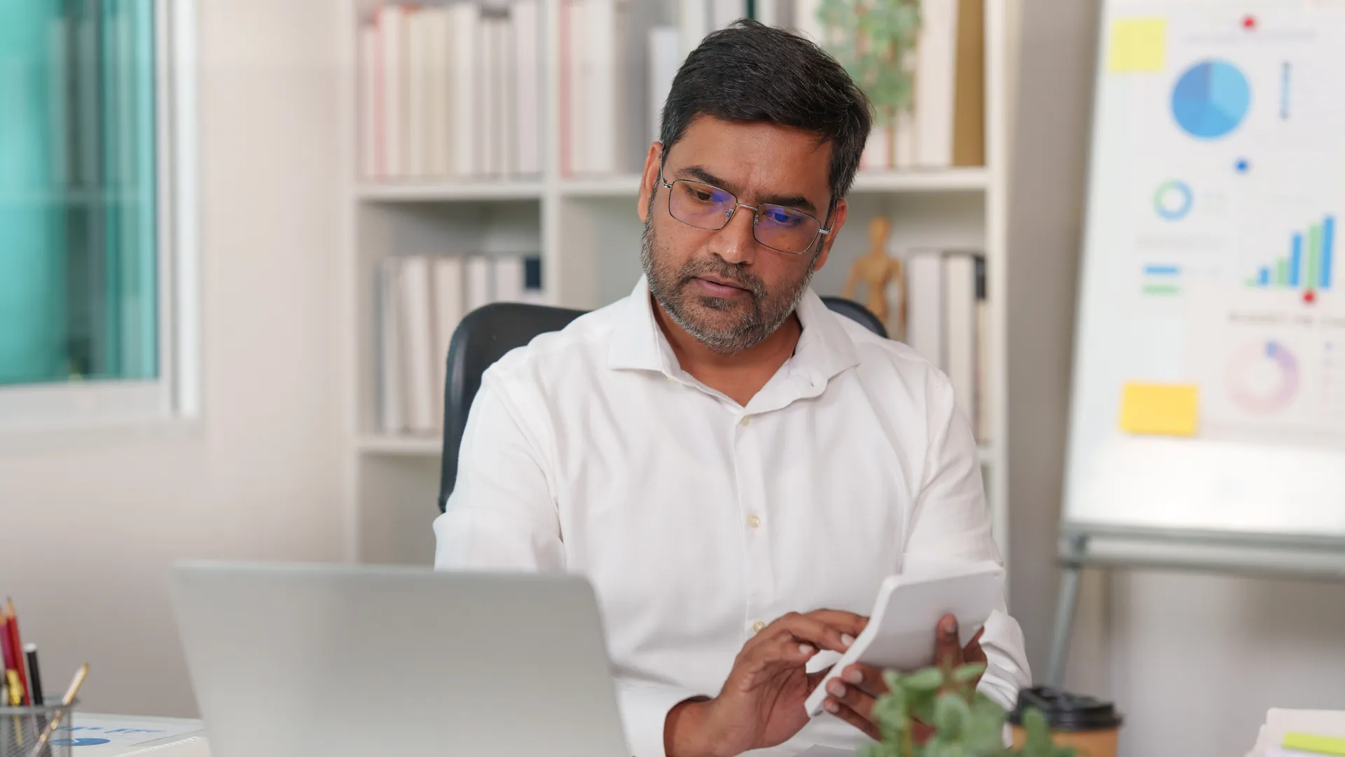 Indian commercial support executive working on accounts at a laptop