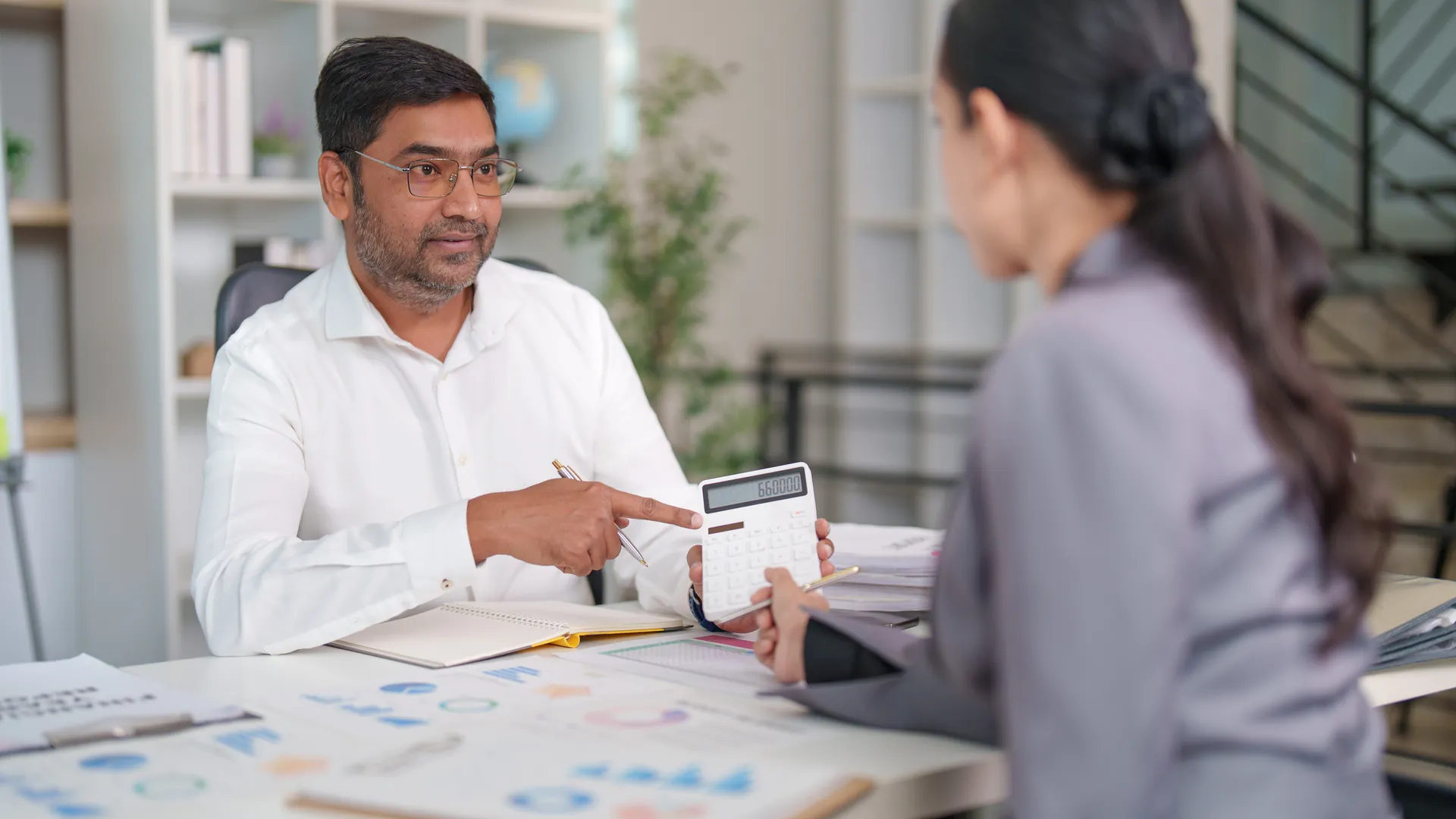 Indian financial advisor walking a client through a loan calculation