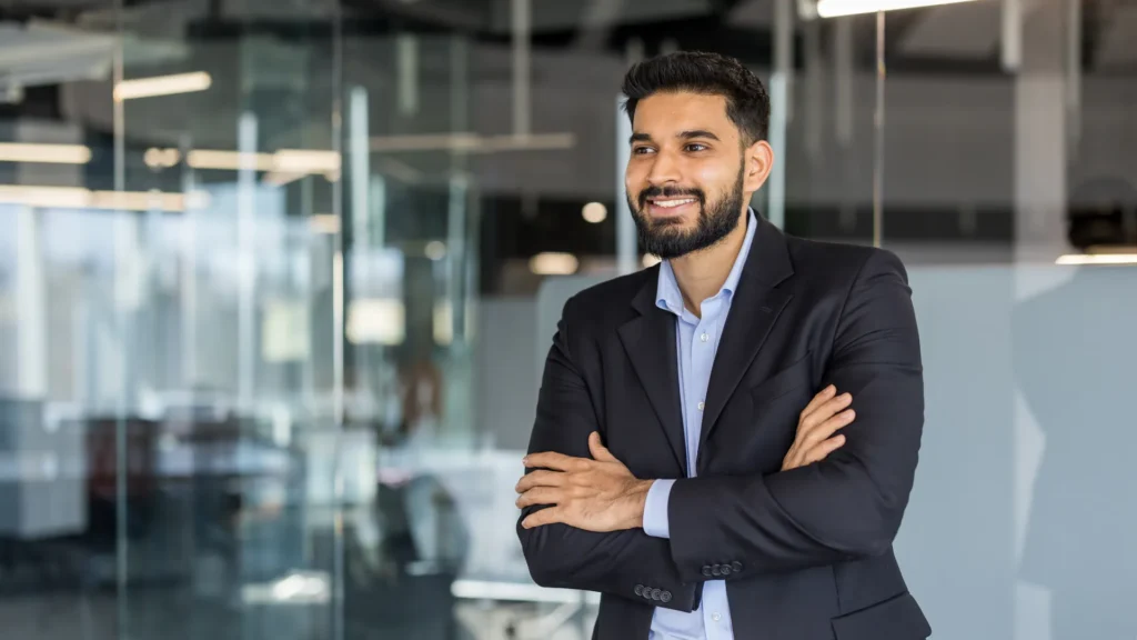 Confident senior executive standing in a modern glass office