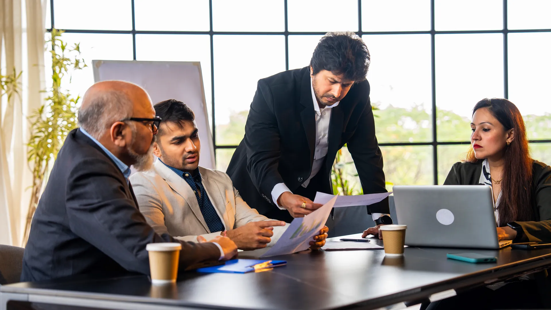 Team of professionals reviewing compliance documents together in a boardroom