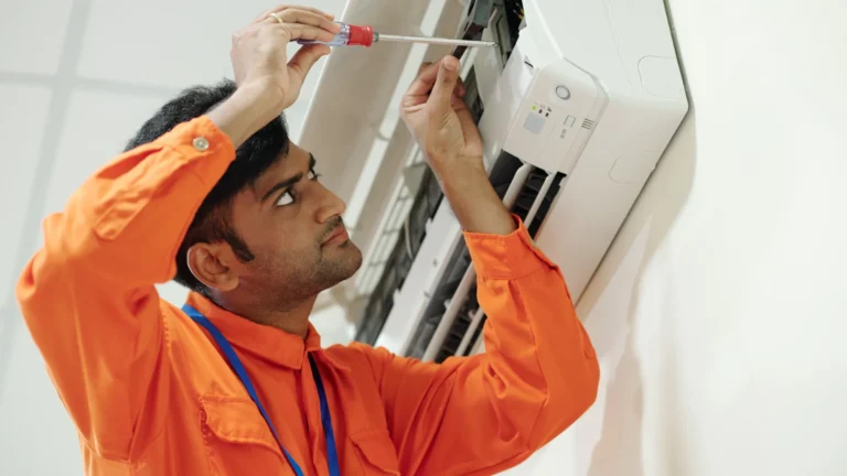 Indian service technician installing an air conditioner