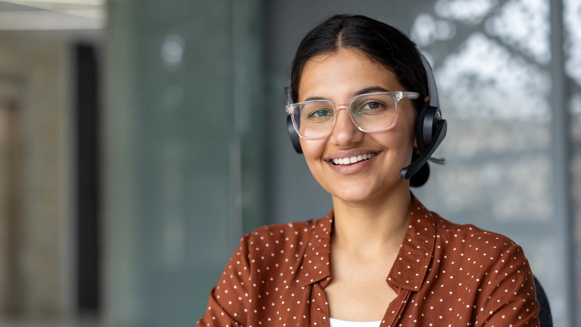 Indian tele-sales agent with a headset in a modern office