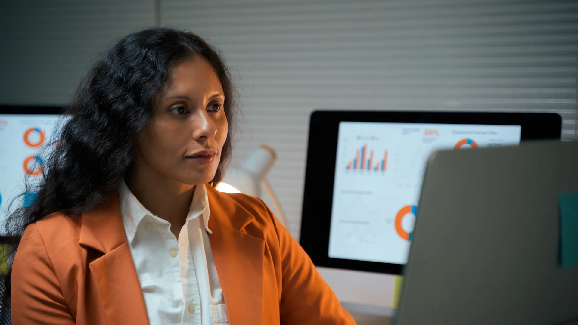 Professional analysing workforce dashboards on computer screens