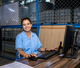 Smiling warehouse office worker at a computer