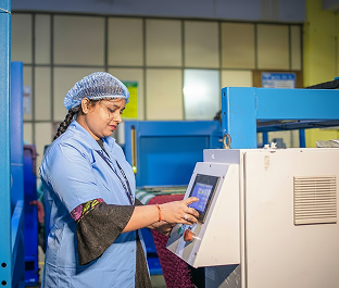 Factory worker operating a digital control panel